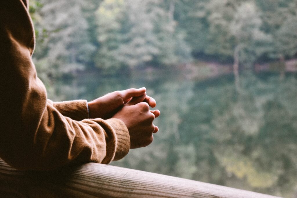 male looking at lake from house